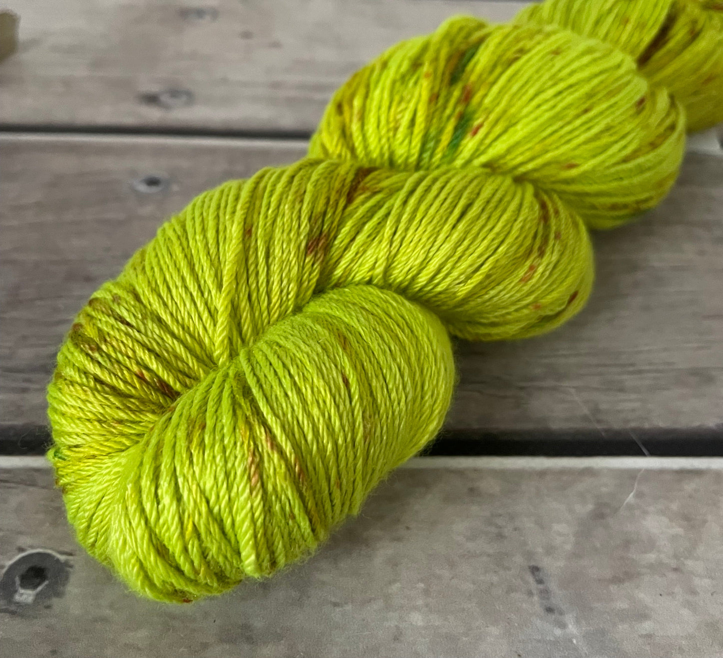 Bright green skein of yarn on a wooden surface