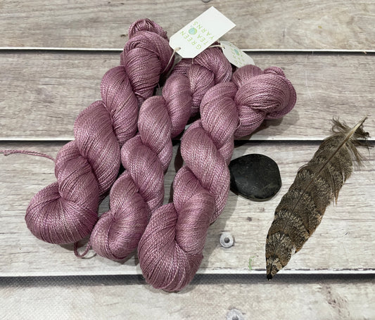 A soft muted pink skein of pure silk yarn called Tea Rose